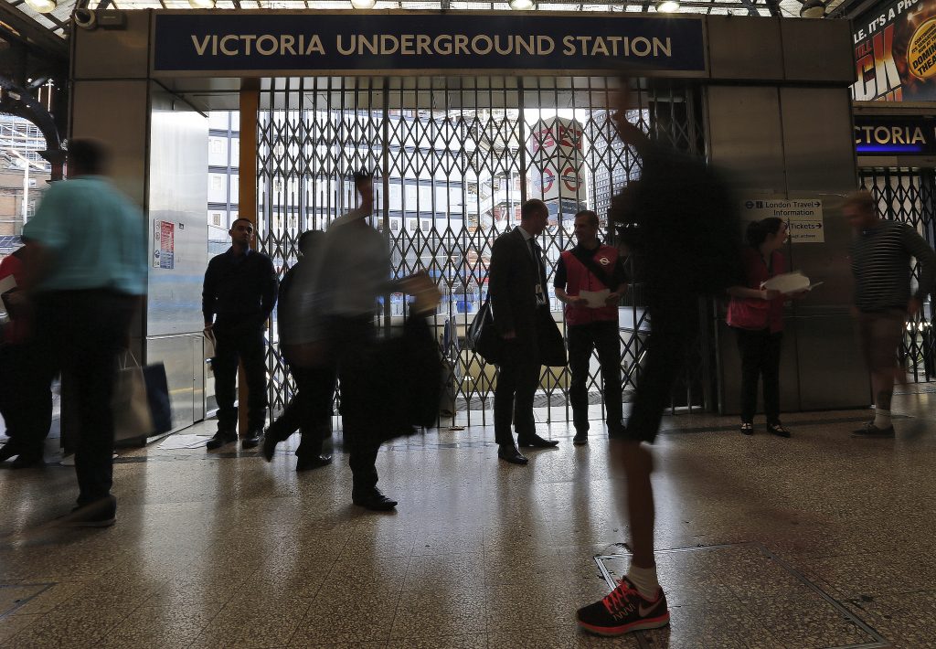 Commuters rush by the closed tube entrance at Victoria station as tube drivers are on strike in London, Thursday, July 9, 2015. Drivers and station staff were walking out for 24 hours from 6:30 p.m. (1730GMT) Wednesday in a dispute over pay and schedules when a 24-hour subway service starts on some lines later this year.The Underground handles 4 million journeys a day, and the strike by members of four unions will likely paralyze the capital's transport system, despite extra bus and river services.