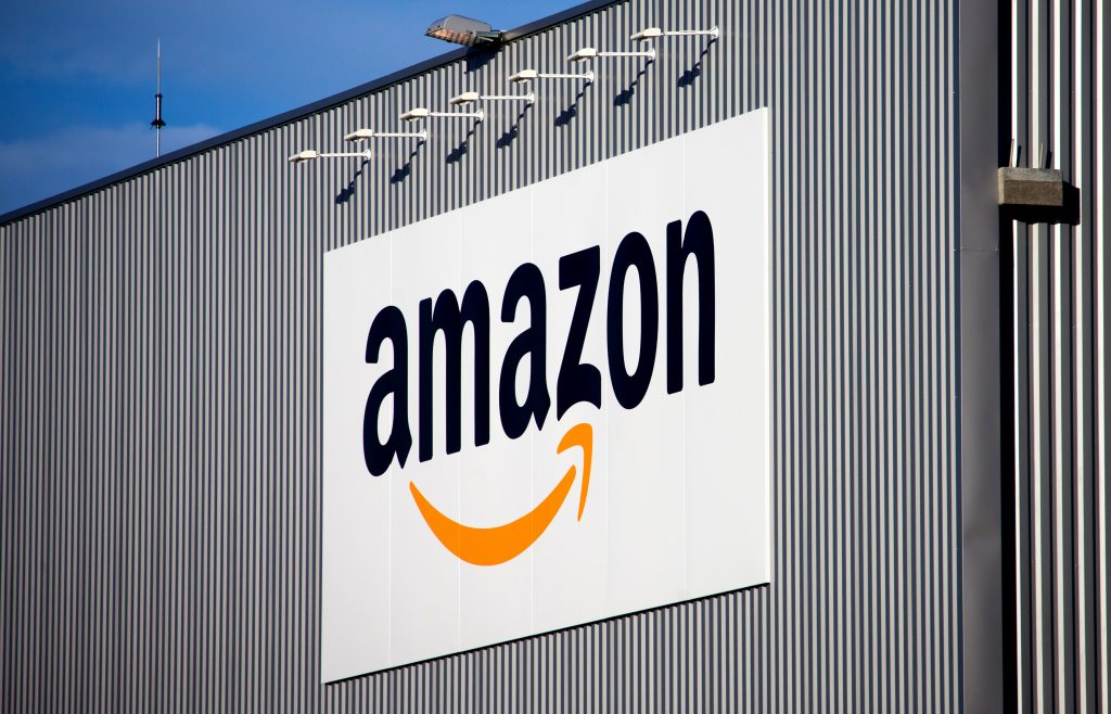 FILE - This Sept. 19 2013 file photo, the Amazon logo is seen on the new logistics center of online merchant Amazon in Lauwin-Planque, northern France. French economy minister Bruno Le Maire has launched a lawsuit against American e-commerce giant Amazon for imposing unfair commercial relationships to suppliers in the country. (AP Photo/Michel Spingler, File)