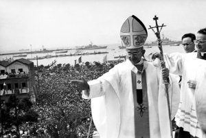 Pope Paul VI, wearing miter and carrying a crosier, salutes a cheering crowd gathered in the huge square in front of the Basilica of St. Mary Bonaria at Cagliari, Sardinia, where the Pontiff celebrated mass at a temporary altar April 24, 1970. (Ap Photo)