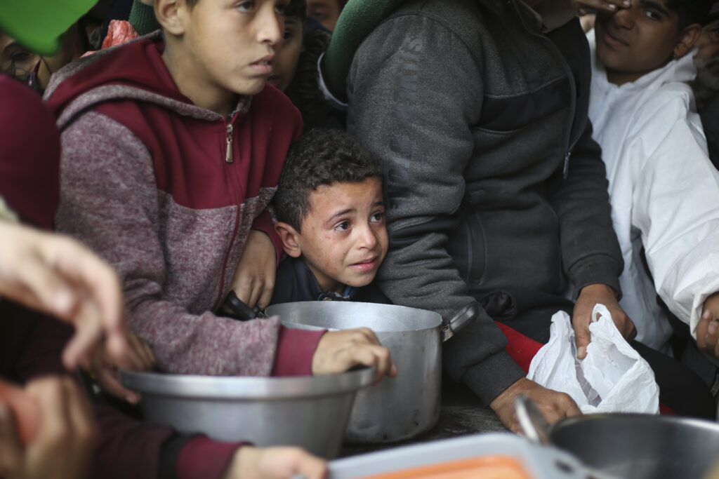 Palestinians line up for free food distribution during the ongoing Israeli air and ground offensive in Khan Younis, Gaza Strip, Friday, Feb. 2, 2024